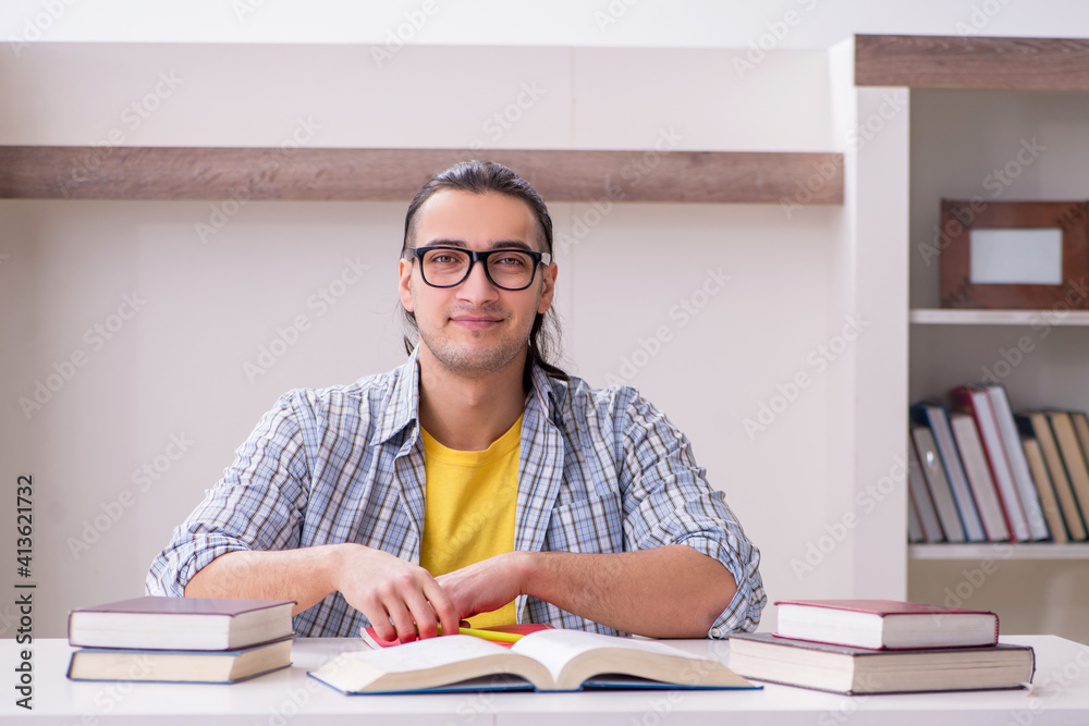 Young male student preparing for exam at home
