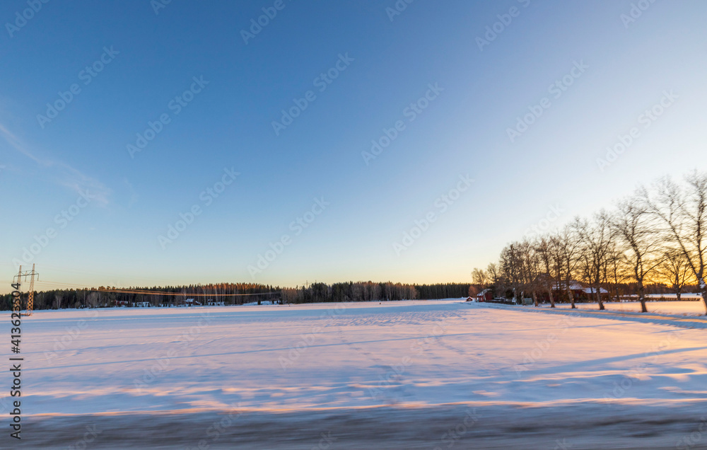 Beautiful nature landscape view on winter day. Field merging with blue sky and white clouds. Beautiful winter background. Sweden. Beautiful nature landscape view on winter day. Field merging with blue sky and white clouds. Beautiful winter background. Sweden.