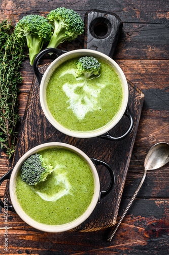 Fresh homemade cream broccoli soup in bowl . Dark Wooden background. Top view
