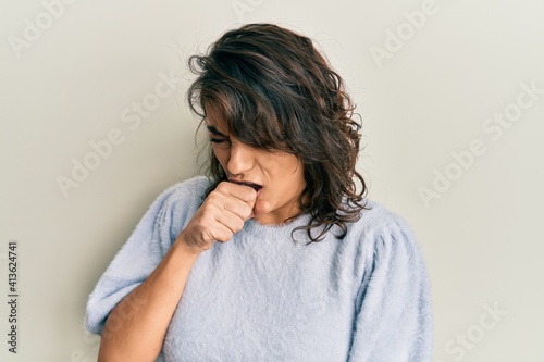 Young hispanic woman wearing casual winter sweater feeling unwell and coughing as symptom for cold or bronchitis. health care concept.