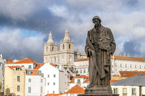 Stone statue of São Vicente, patron saint of Lisbon in the viewpoint called "Sun Gates". In the background the Church or Monastery of São Vicente de Fora 