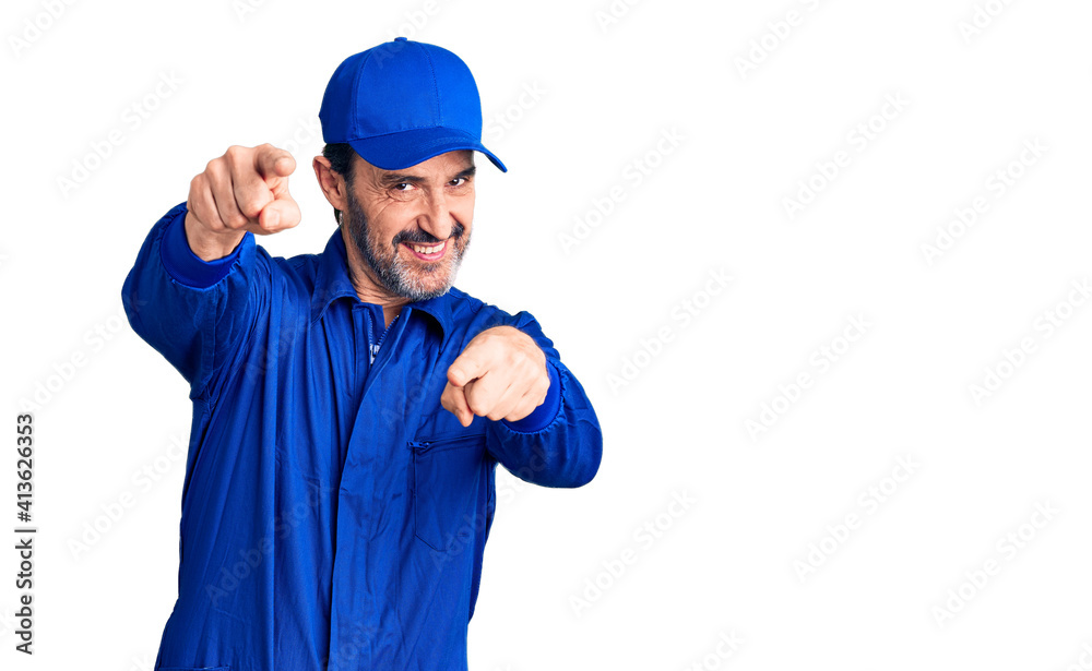 Middle age handsome man wearing mechanic uniform pointing to you and the camera with fingers, smiling positive and cheerful