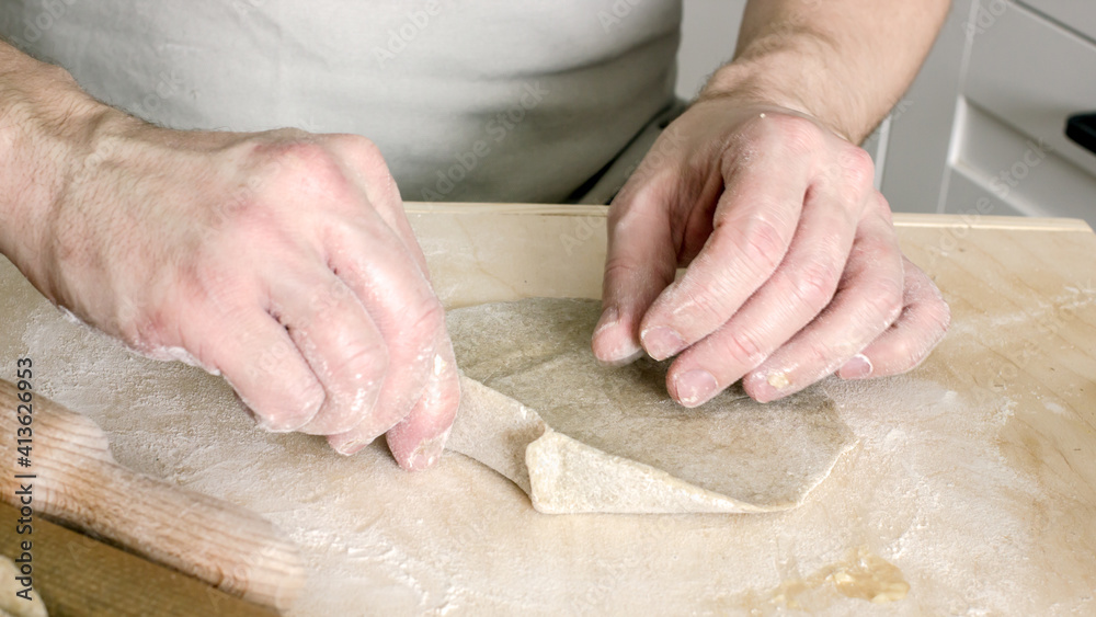 A man without a face bakes national rye dough pies with potato filling. Hands and dough close-up. Step-by-step instructions Recipe for baking a pie. Home baker, authentic home food, hobby baking