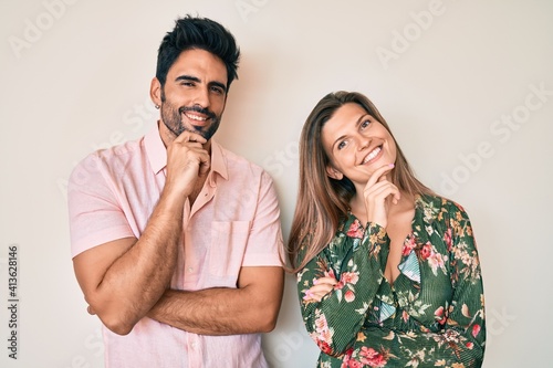 Beautiful young couple of boyfriend and girlfriend together looking confident at the camera with smile with crossed arms and hand raised on chin. thinking positive.
