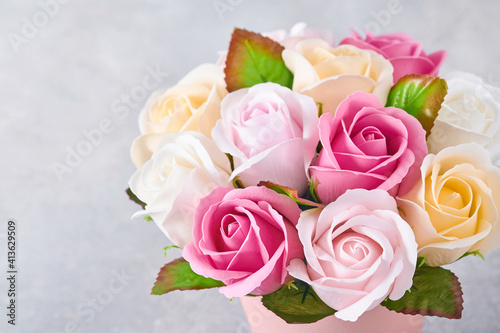 Festive composition with beautiful delicate roses flowers in pink round box on light gray background. Flat lay  copy space.