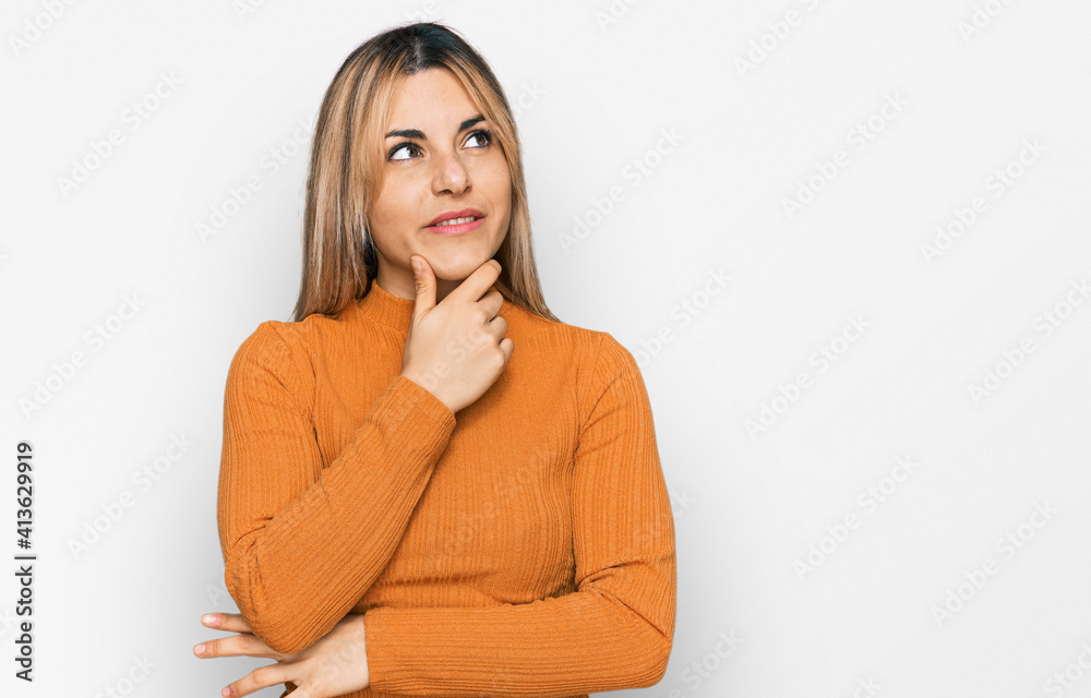 Young caucasian woman wearing casual clothes with hand on chin thinking about question, pensive expression. smiling with thoughtful face. doubt concept. Young caucasian woman wearing casual clothes with hand on chin thinking about question, pensive expression. smiling with thoughtful face. doubt concept.