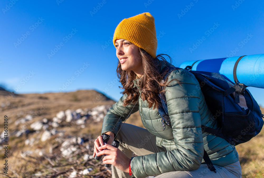Portrait of a smiling young female hiking in the mountain.	