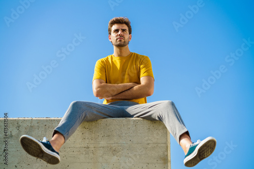 Fotografie Man sitting on a ledge looking around