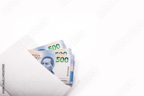 Billetes mexicanos dentro de un sobre blanco, sobre fondo blanco esquinado.
Mexican peso bills inside a white envelope, on a white background. photo