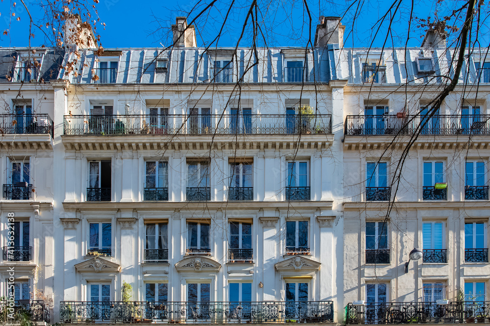 Paris, typical facade, beautiful building, with heads sculpted above the windows
