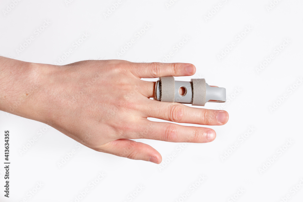 left palm with Grey plastic two-sided Finger Splint with two convenient hook-and-loop straps on a broken ring finger, holding a finger straight with orthopedic device, male left hand with medical tool left palm with Grey plastic two-sided Finger Splint with two convenient hook-and-loop straps on a broken ring finger, holding a finger straight with orthopedic device, male left hand with medical tool