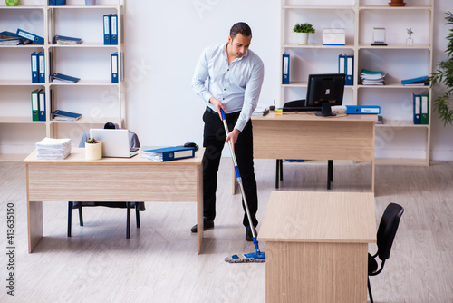 Young male employee cleaning office during pandemic