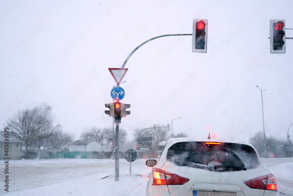 PKW im Schnee an roter Ampel