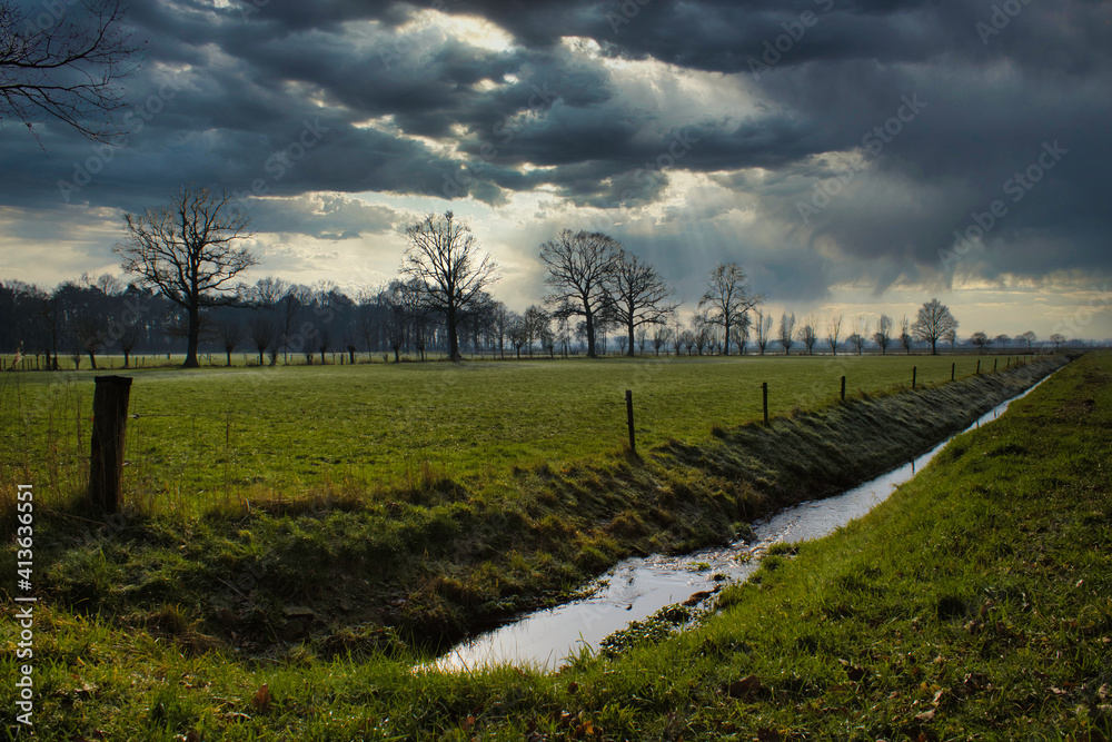 Dutch landscape with farmlands and heavy clouds during storm