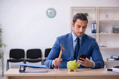 Aggressive male employee with hammer in budget planning concept