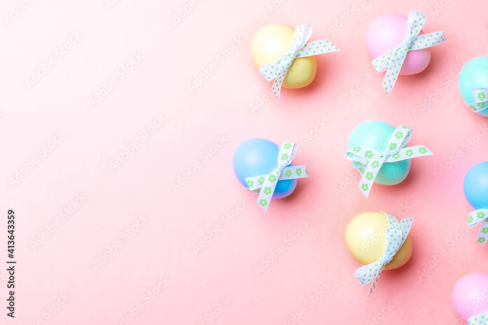Easter decoration. Colourful egg with tape ribbon on pastel pink background in Happy Easter decoration. Foil minimalist egg design with copy space.