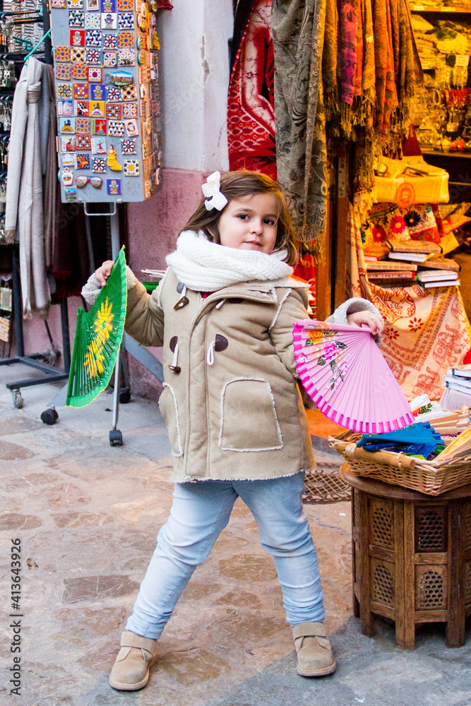 girl with fans in a typical andalusian stall