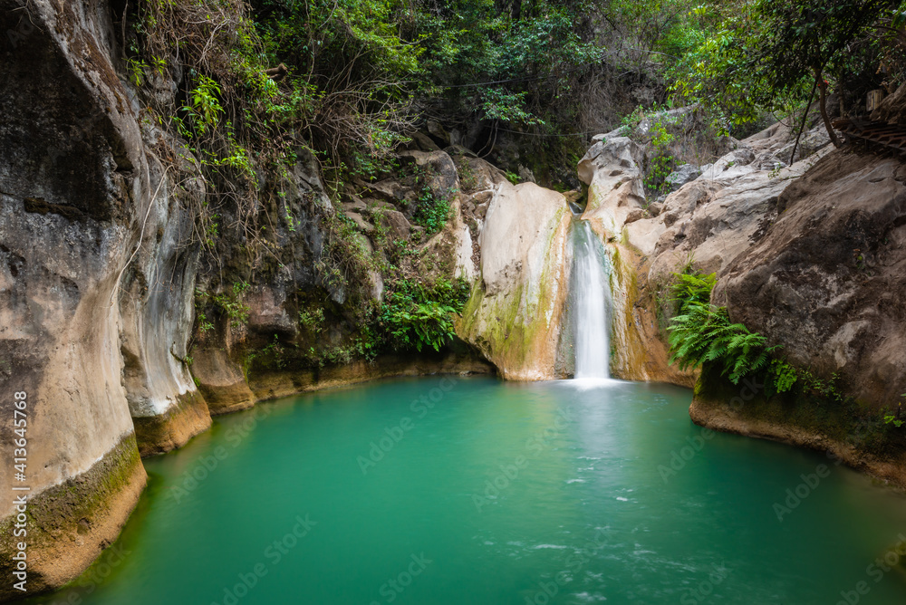 Obraz premium Waterfall in the middle of the jungle, small stream with crystal clear waters, in Taxco, Guerrero, Mexico
