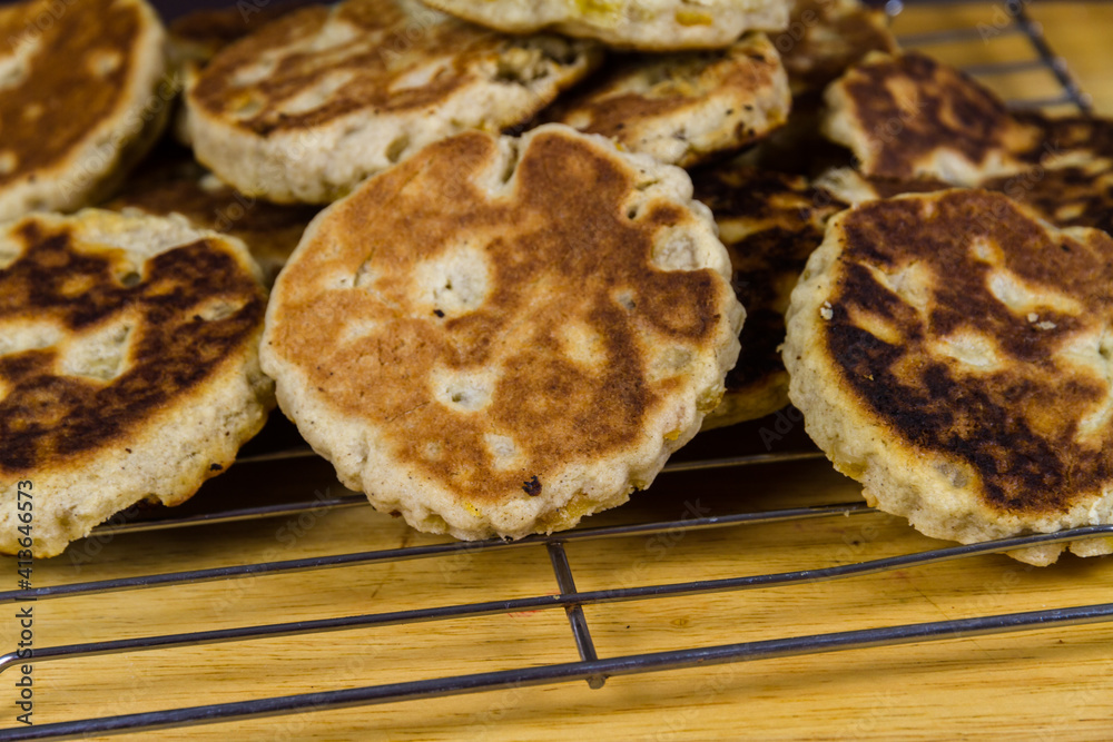 Freshly cooked sugared welshcakes on a cooling rack close up.