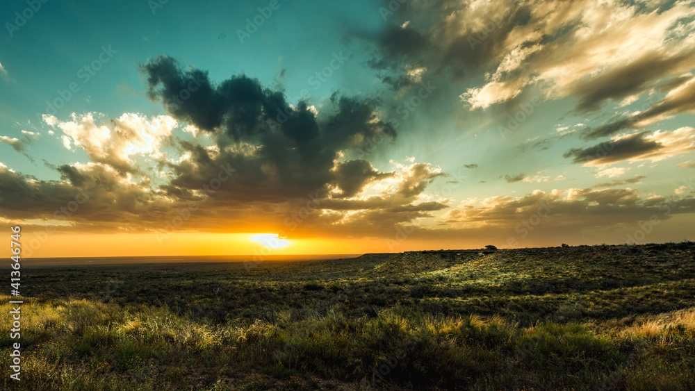 Panoramic of the sunset during the golden hour with landscape of Patagonian plateau and partly cloudy sky