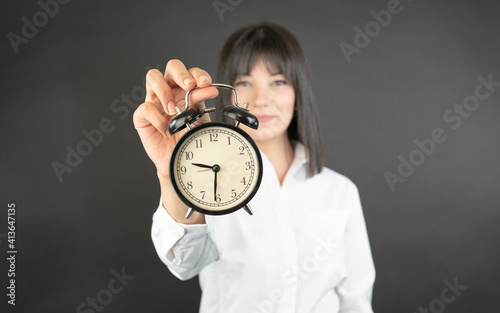 Business woman holding alarm clock. 