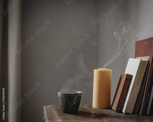 Dampfende Teetasse und gelöschte Kerze  photo