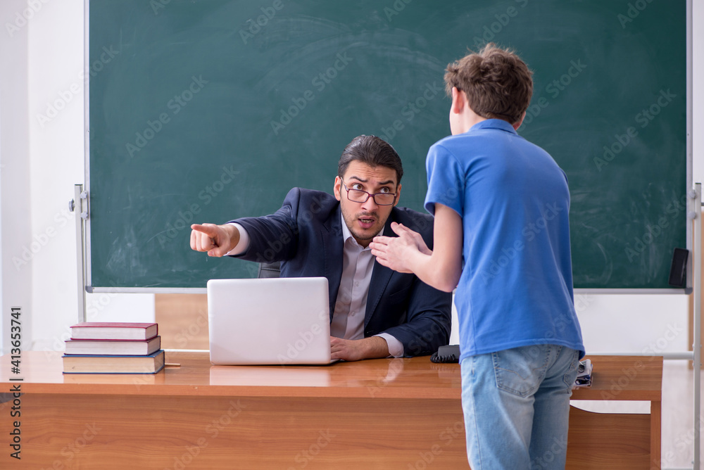 Young male teacher and schoolboy in the classroom Young male teacher and schoolboy in the classroom