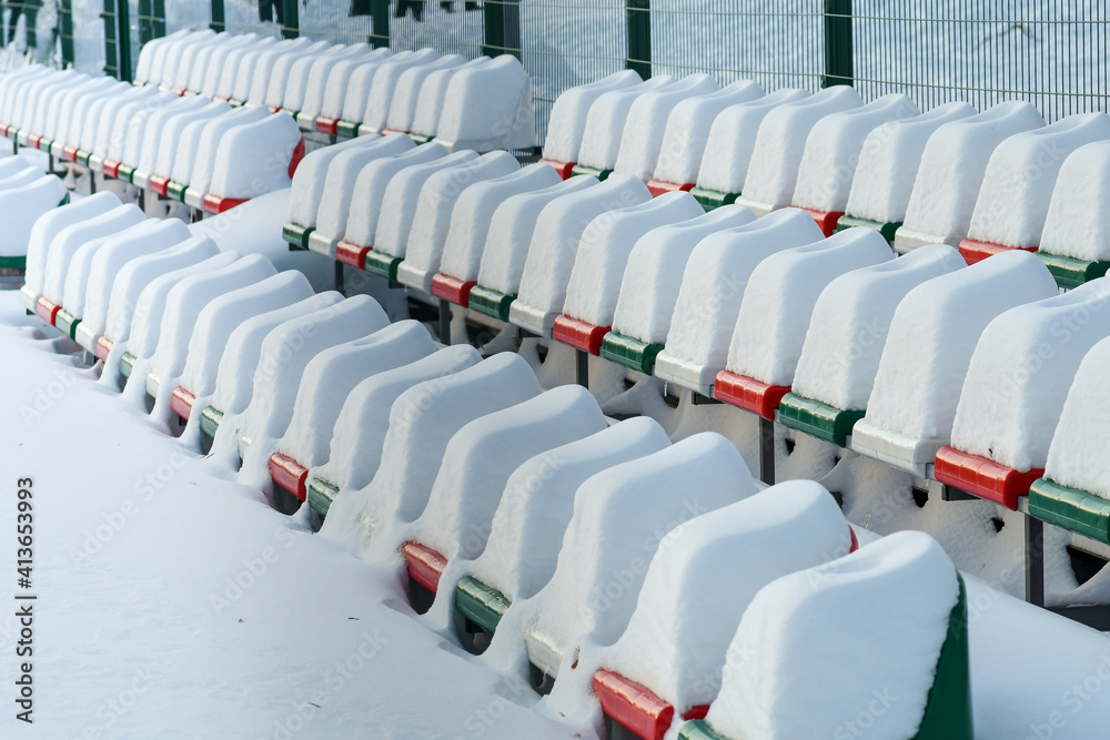 Fototapeta premium Raws of outdoor stadium seats heavily covered with snow 