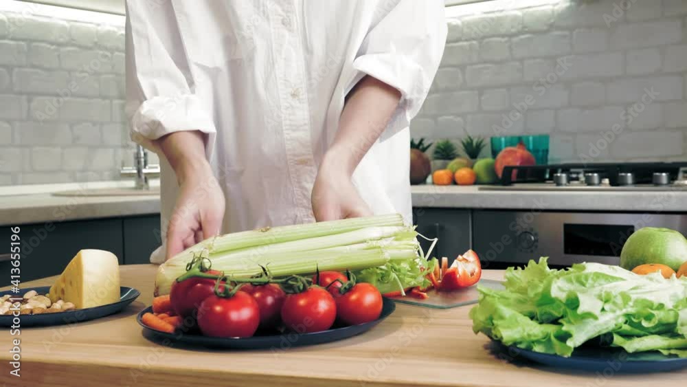 cooking online. healthy food. close-up. woman puts a plate of vegetables on table and chopping pepper on glass board. culinary vlogging, social networks cooking online. healthy food. close-up. woman puts a plate of vegetables on table and chopping pepper on glass board. culinary vlogging, social networks