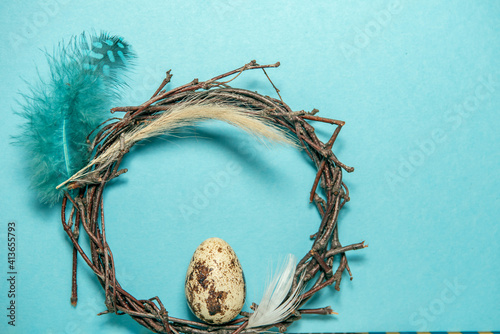 This Easter wreath is decorated with spikelets and feathers. Quail egg in the center