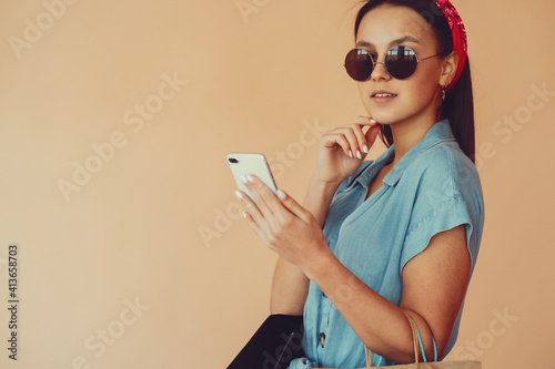 Girl with shopping bags. Lady on a yellow background. Woman in a blue dress.