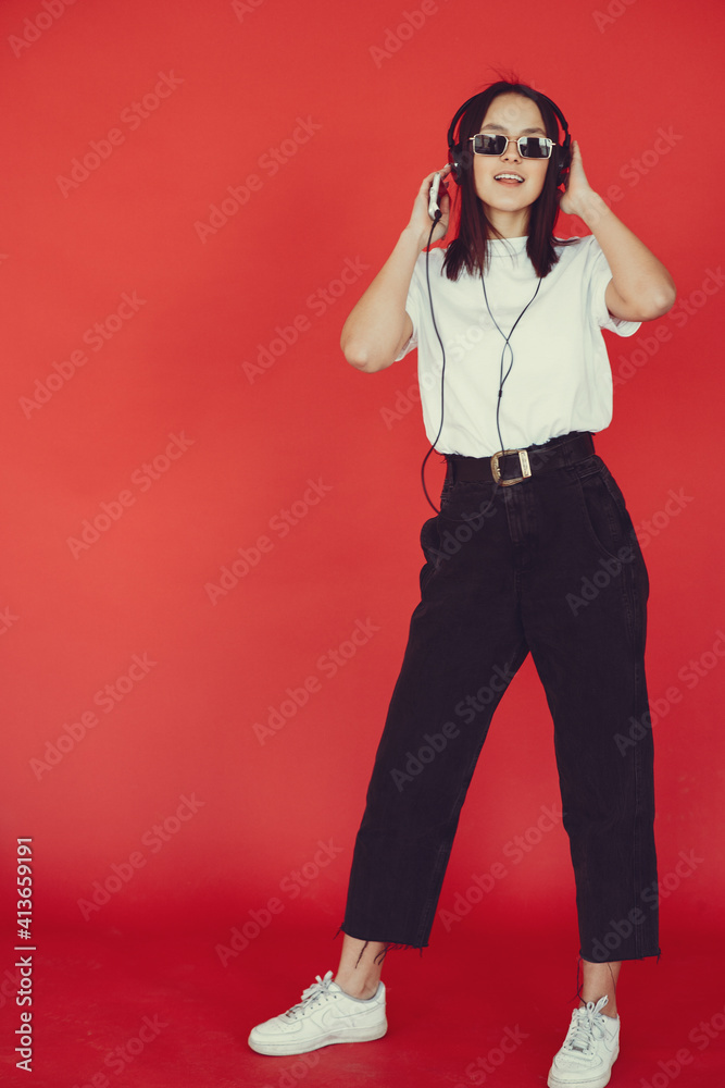 Girl with headphones. Lady on a red background. Woman in a white t-shirt. Girl with headphones. Lady on a red background. Woman in a white t-shirt.
