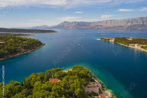 POVLJA, CROATIA - August 2020: Beautiful village Povlja on island Brac with mountain Mosor in background. Panoramic view. Aerial drone shot.