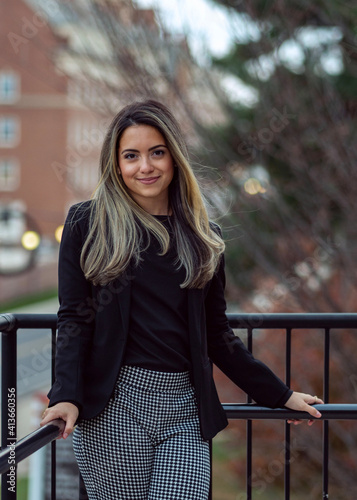 Young business woman leaning on post in urban office