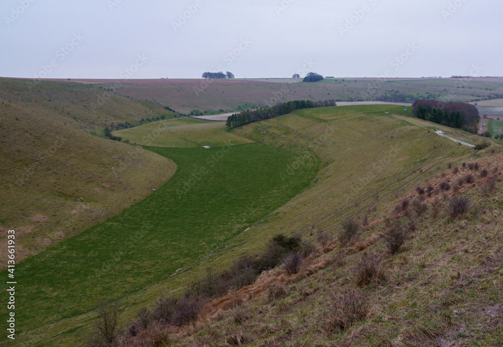 view of the up-faulted Southern edge of Pewsey Vale with copse woodland in the valley near Pewsey, Wiltshire