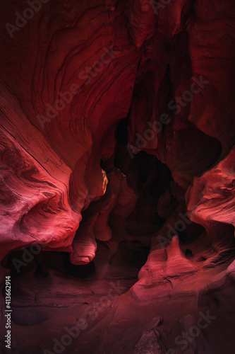 Amazing sandstone formations inside a cave in Coves De Can Riera caves in Torrelles, Barcelona, Catalonia, Spain. Vibrant red colors of eroded rock with wave forms similar to famous Grand Canyon, USA. photo