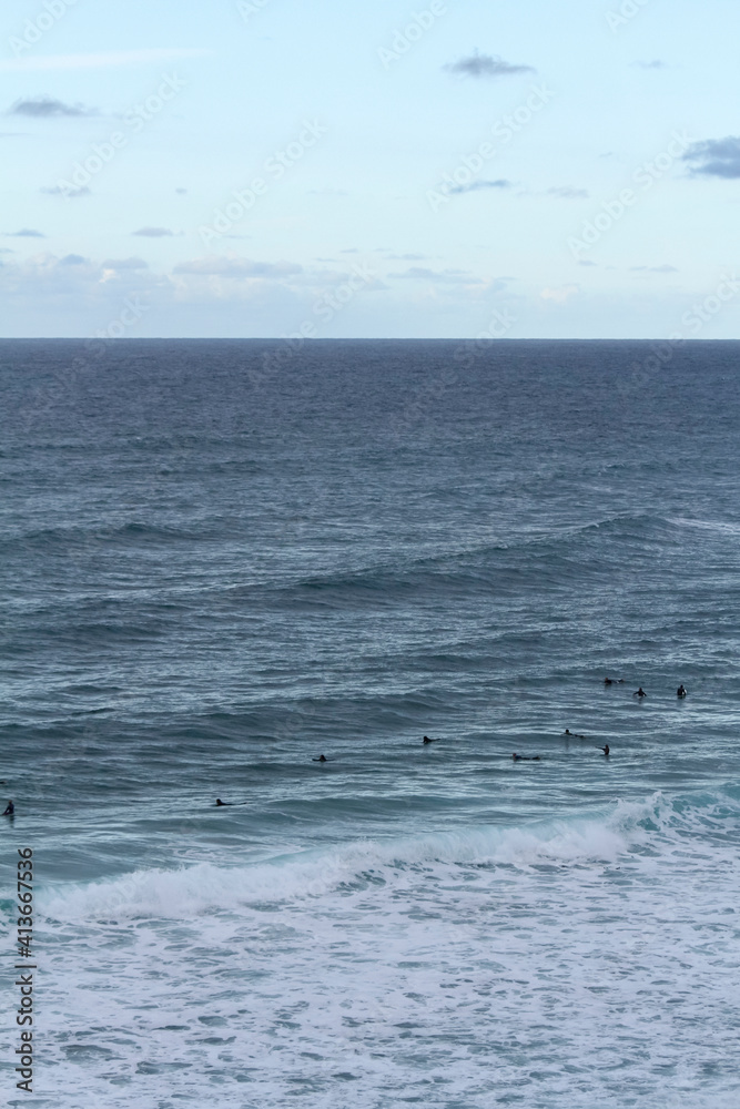 Many surfers sit and lie on their surfboards between breaking approaching waves on a beach in Portugal on the Atlantic Ocean Many surfers sit and lie on their surfboards between breaking approaching waves on a beach in Portugal on the Atlantic Ocean