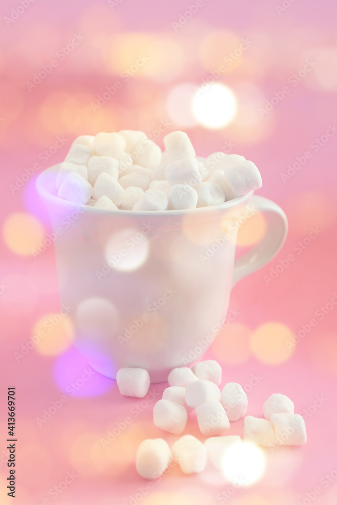Sweet marshmallows in a white cup with and bright bokeh background. Holiday and food concept. Sweet marshmallows in a white cup with and bright bokeh background. Holiday and food concept.