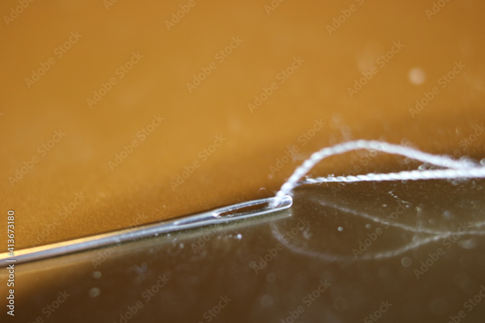 Needle and thread close up Needle and thread close up