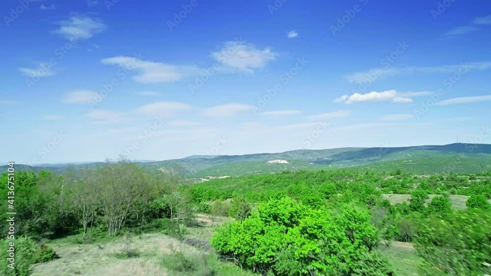 Countryside mountain landscape with green trees and blue sky horizon, sunny day, aerial forward motion view Countryside mountain landscape with green trees and blue sky horizon, sunny day, aerial forward motion view