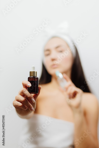 woman using face serum as skin care routine. Caucasian female applies hyaluronic acid as a skin care routine for wrinkles prevention.