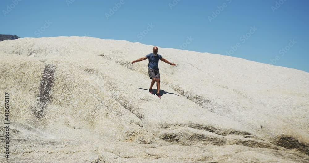 Senior african american man exercising running on rocks by the sea Senior african american man exercising running on rocks by the sea