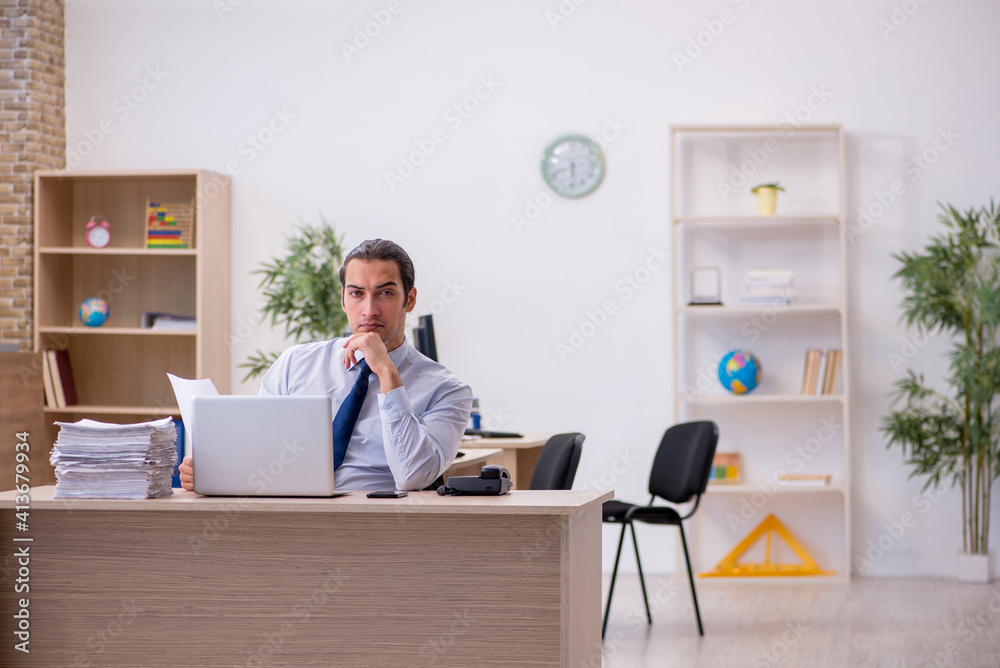 Young male employee sitting in the office Young male employee sitting in the office