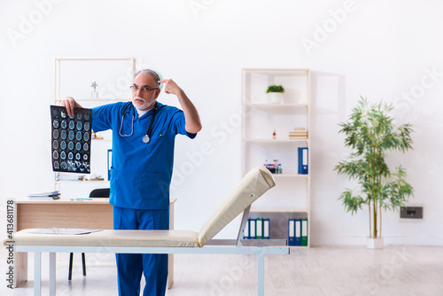 Old male doctor radiologist working in the hospital