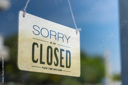Closed sign broad through the glass of door in cafe., Sorry we're closed sign., Business service and food concept.