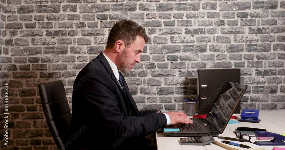 Business man getting frustrated on laptop computer in small office