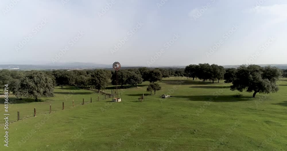 Aerial video Old wind power pump in Spanish farm surrounded by holm oaks Aerial video Old wind power pump in Spanish farm surrounded by holm oaks