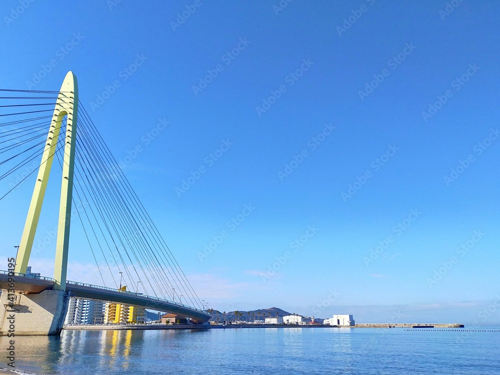Naklejka premium 快晴の青空を背景にした斜張橋のある風景