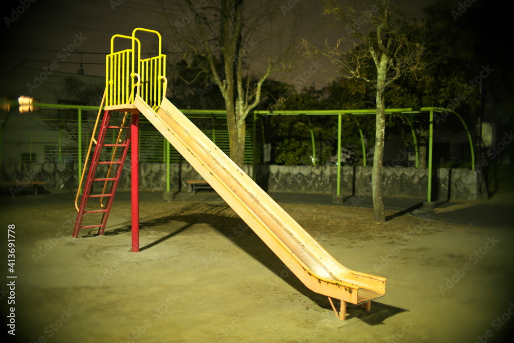 Fototapeta premium Tokyo,Japan-February 13, 2021: Vacant playground slide in a park at night in Tokyo