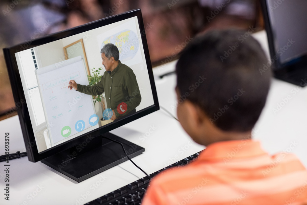 Mixed race schoolboy using computer on video call with male teacher Mixed race schoolboy using computer on video call with male teacher